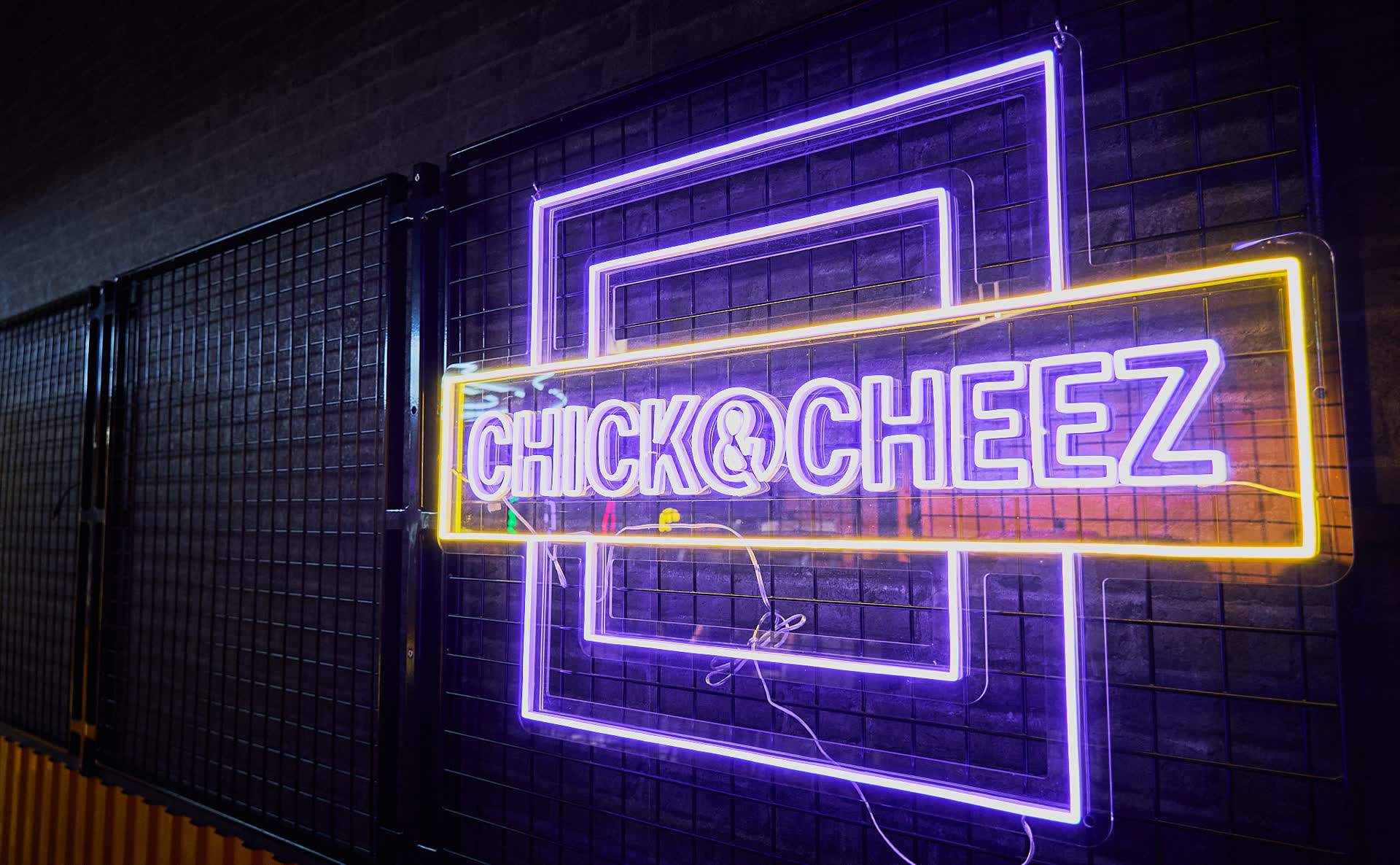 De neonreclame van Chick & Cheez aan de gevel van de zaak.